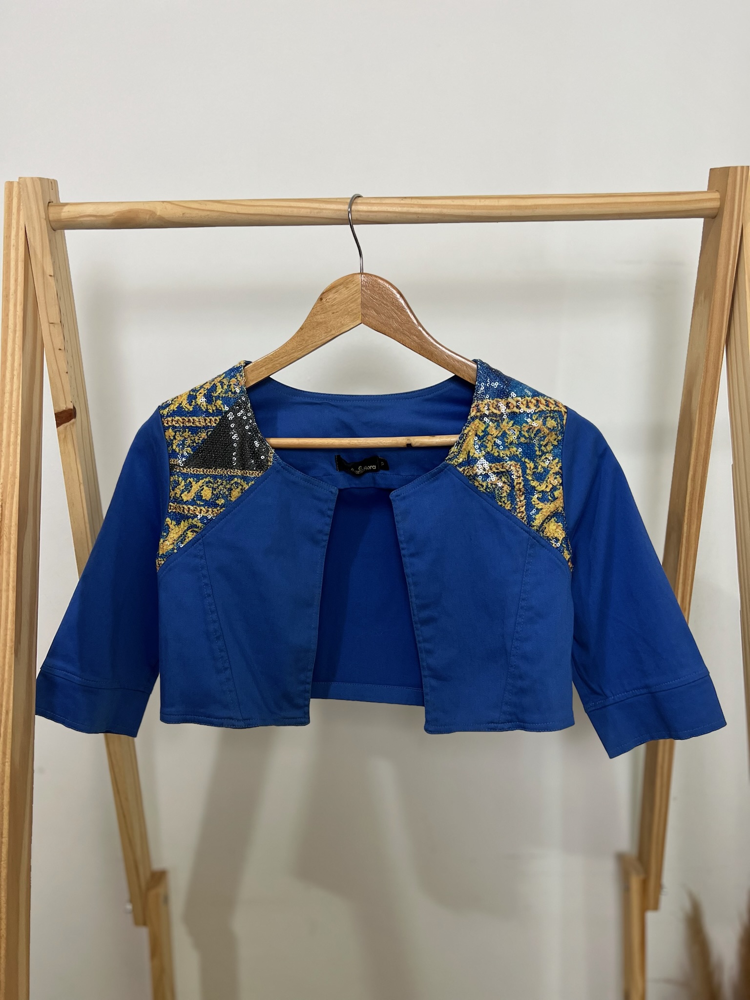 Colete curto azul com detalhes em paetê